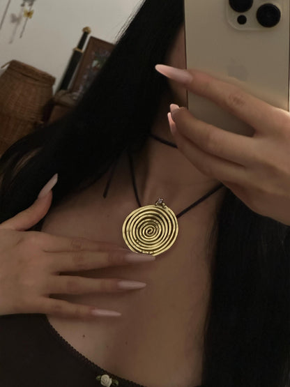 Spiral Pendant Necklace: A Sculptural Brass Piece with Zircon Detail